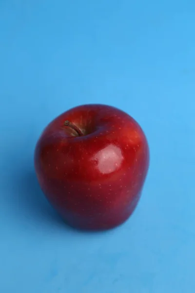 Plan Vertical Une Pomme Rouge Entière Isolée Sur Fond Bleu — Photo