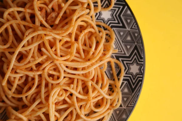 黄色の背景にプレートにスパゲティのクローズアップショット — ストック写真