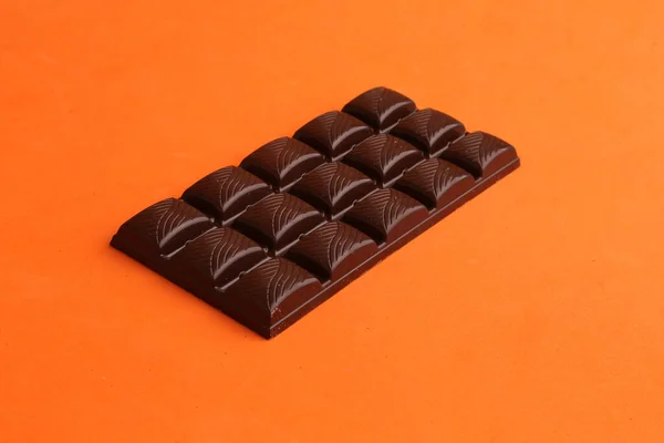 Tiro Close Comprimido Chocolate Leite Fundo Laranja — Fotografia de Stock