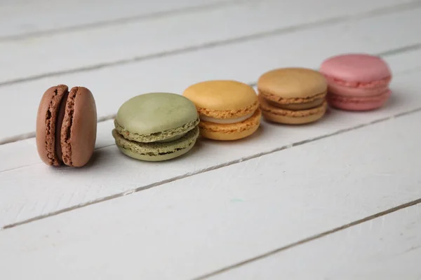 Eine Gruppe Farbenfroher Macarons Auf Weißem Holzgrund — Stockfoto