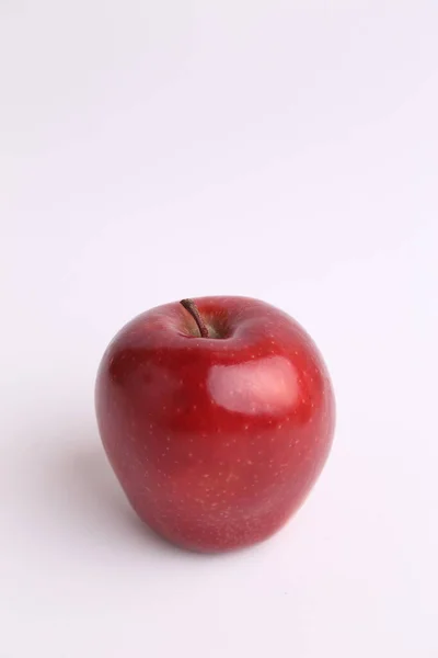 Vertikal Bild Ett Skinande Ljust Rött Äpple Vit Yta — Stockfoto