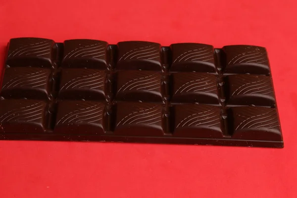 Eine Nahaufnahme Von Dunkler Schokolade Auf Rotem Hintergrund — Stockfoto