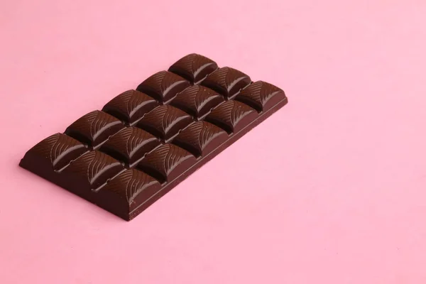 Eine Nahaufnahme Eines Schokoladenblocks Einem Schrägen Winkel Auf Einer Rosafarbenen — Stockfoto