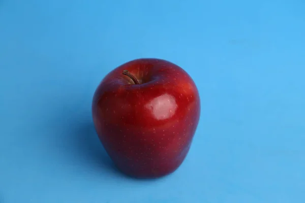 Närbild Ett Läckert Rött Äpple Framför Blå Bakgrund — Stockfoto