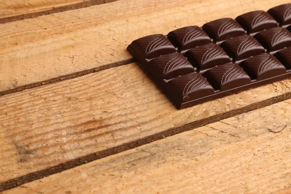 Tiro Close Uma Barra Chocolate Escuro Fundo Madeira — Fotografia de Stock