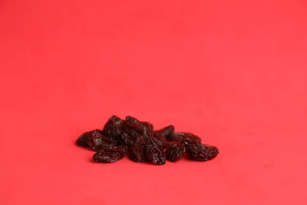Pila Algunas Ciruelas Secas Negras Aisladas Sobre Fondo Rojo — Foto de Stock