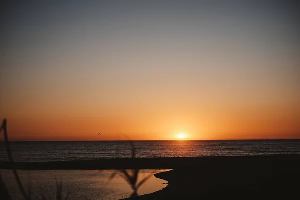 Ένα Όμορφο Πλάνο Μιας Παραλίας Στο Λαμπερό Ηλιοβασίλεμα Πίσω Από — Φωτογραφία Αρχείου