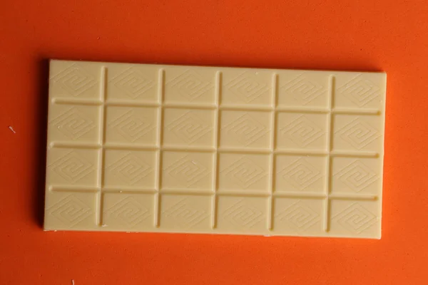 Una Barra Chocolate Blanco Sobre Una Superficie Naranja —  Fotos de Stock