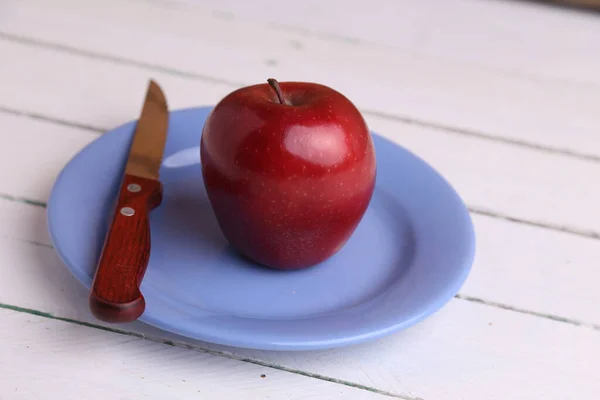 Primer Plano Una Manzana Roja Cuchillo Plato Azul Una Mesa — Foto de Stock