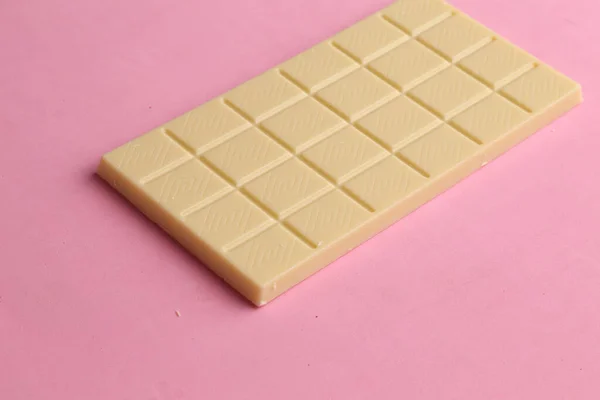 Stock image A closeup shot of a bar of white chocolate on a pink surface