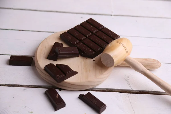 Uma Barra Chocolate Escuro Uma Placa Madeira Com Martelo Martelo — Fotografia de Stock