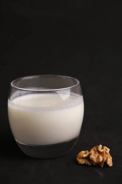 Ett Glas Mjölk Bredvid Bit Valnöt Svart Bakgrund — Stockfoto