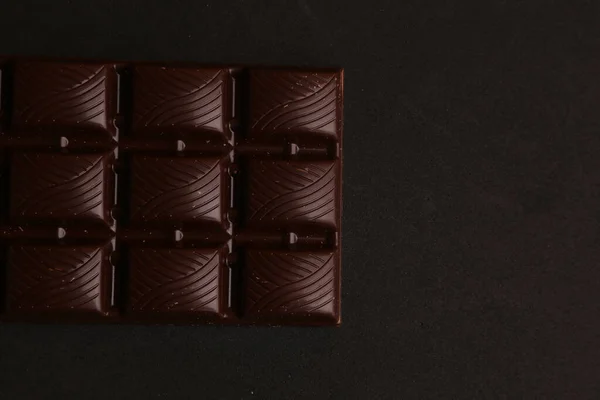 Nahaufnahme Einer Tafel Dunkler Schokolade Auf Schwarzem Hintergrund — Stockfoto
