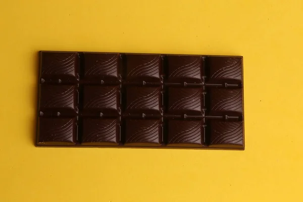 Una Toma Aérea Una Barra Chocolate Negro Sobre Fondo Amarillo — Foto de Stock