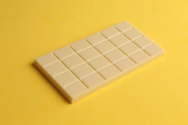Uma Barra Chocolate Branco Uma Superfície Amarela — Fotografia de Stock