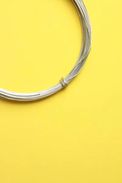 Eine Vertikale Aufnahme Einer Rolle Metalldraht Isoliert Auf Gelbem Hintergrund — Stockfoto