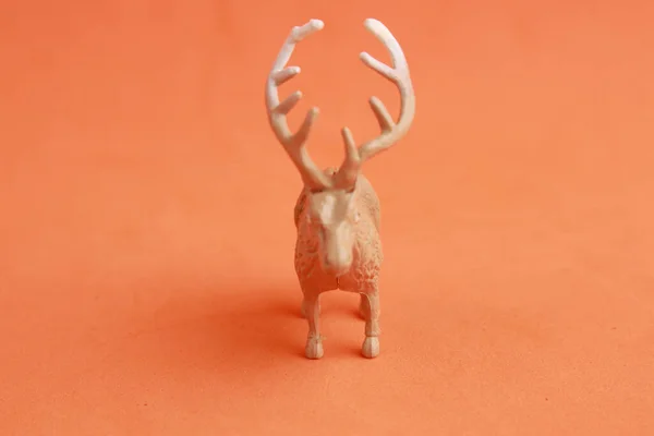 橙色背景的小塑料驯鹿玩具 — 图库照片