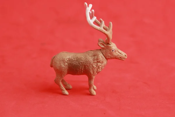 赤い背景にゴム製のおもちゃの鹿のクローズアップショット — ストック写真