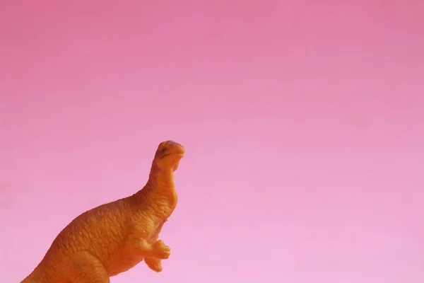 Mały Dinozaur Zabawka Różowym Tle — Zdjęcie stockowe
