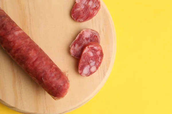 Primo Piano Una Salsiccia Affettata Tagliere Rotondo Legno Sfondo Giallo — Foto Stock