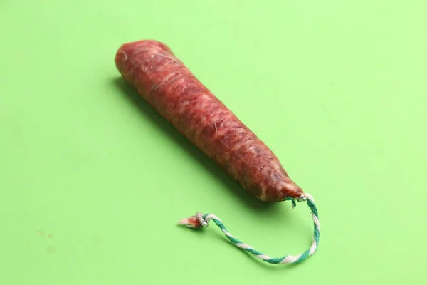 Disparo Alto Ángulo Una Salchicha Chorizo Sobre Una Superficie Verde — Foto de Stock