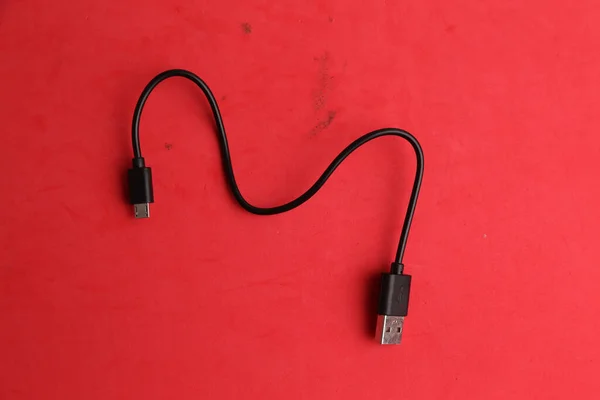 Cable Usb Negro Sobre Una Superficie Roja — Foto de Stock