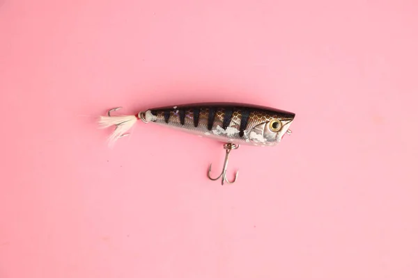 ピンクの背景に釣りのルアーのクローズアップ — ストック写真