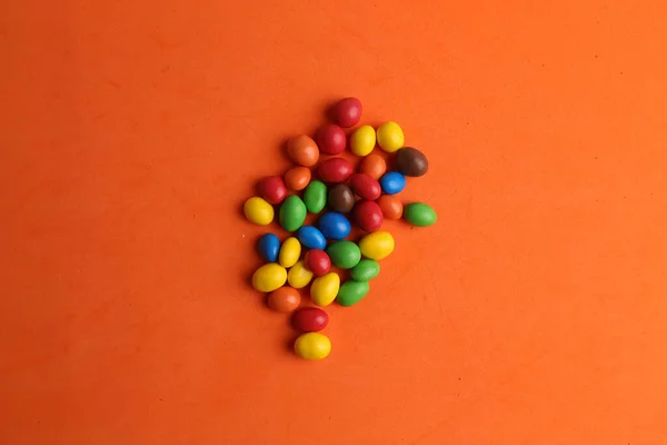 오렌지 배경에 분리되어 색깔의 사탕의 — 스톡 사진