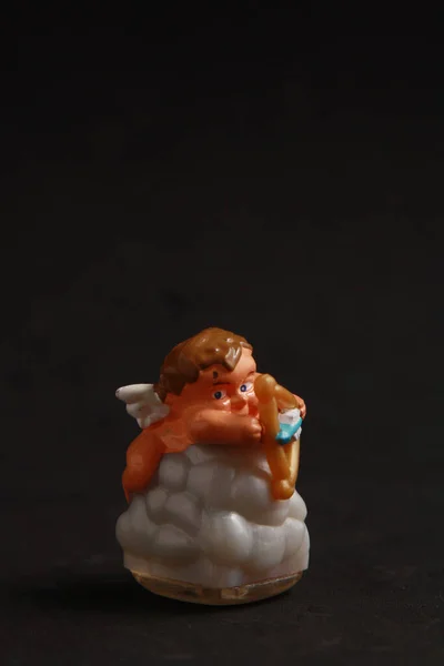Een Verticaal Shot Van Plastic Cupido Vormige Speelgoed Kleur Achtergrond — Stockfoto