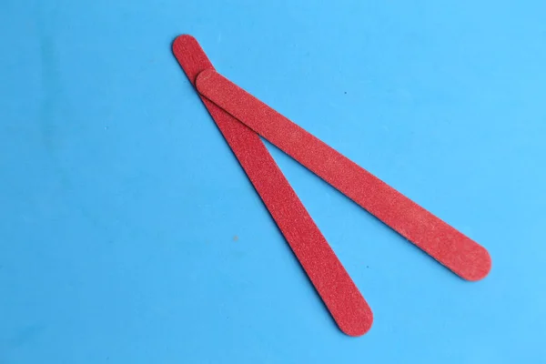 Twee Rode Nagelvijlen Een Blauw Oppervlak — Stockfoto