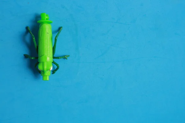 Крупним Планом Знімок Зеленої Коник Подібної Пластикової Іграшки Синьому Фоні — стокове фото