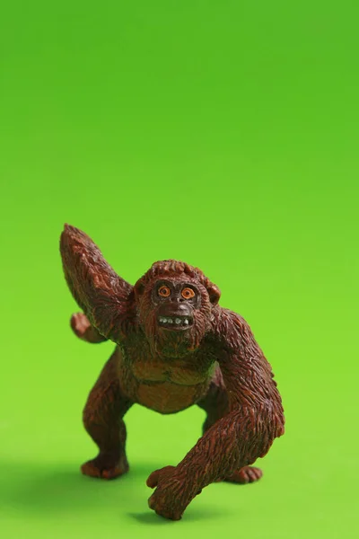 Vertical Closeup Shot Rubber Toy Chimpanzee Green Background — Stock Photo, Image