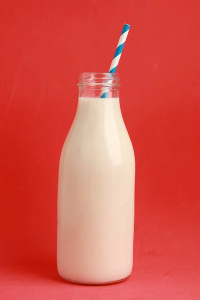 Gros Plan Lait Dans Une Bouteille Verre Sur Fond Rouge — Photo