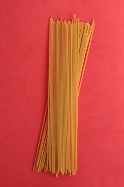 Pionowe Ujęcie Surowego Spaghetti Różowym Tle — Zdjęcie stockowe