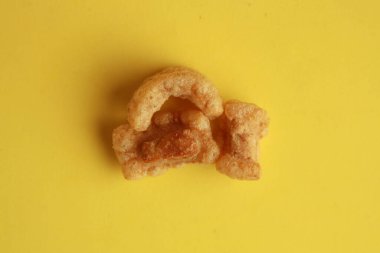 A high angle closeup shot of Spanish Torreznos on a yellow background clipart