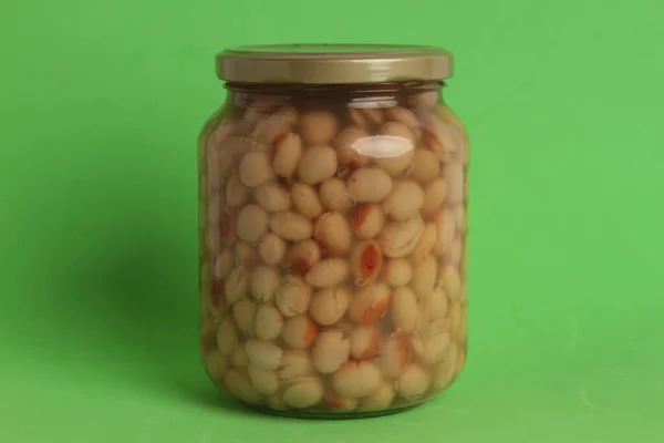 緑の背景に乾燥した豆の瓶 — ストック写真