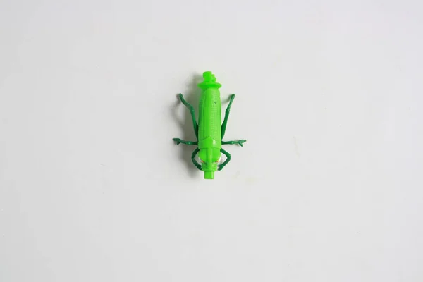 Nahaufnahme Eines Grünen Insektenförmigen Plastikspielzeugs Auf Grauem Hintergrund — Stockfoto