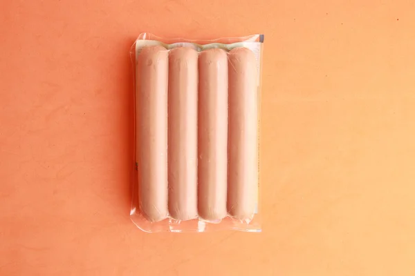 Een Hoge Hoek Shot Van Worsten Plastic Verpakking Een Oranje — Stockfoto