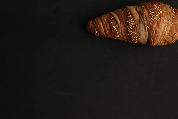 Uma Vista Superior Único Croissant Delicioso Fundo Preto — Fotografia de Stock