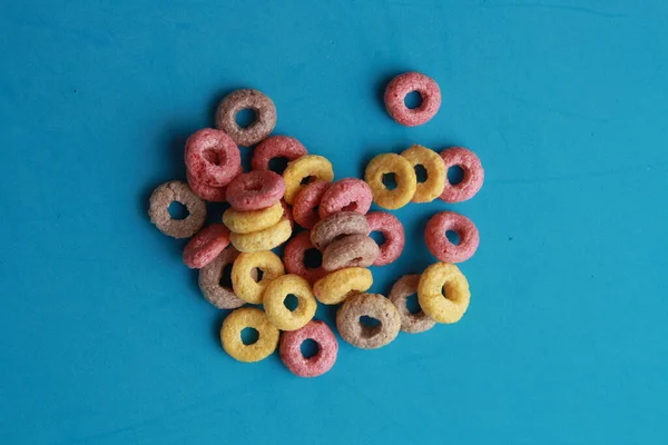 Tiro Alto Ángulo Bucles Fruta Colores Aislados Una Superficie Azul —  Fotos de Stock