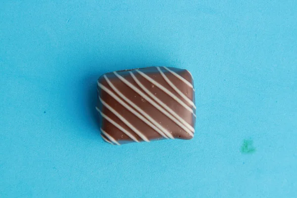 Detailní Záběr Čokoládového Bonbonu Modrém Povrchu — Stock fotografie