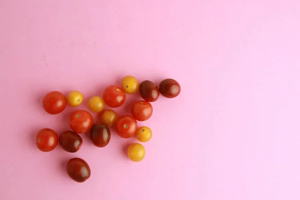 Tiro Alto Ángulo Tomates Cherry Coloridos Sobre Fondo Rosa — Foto de Stock