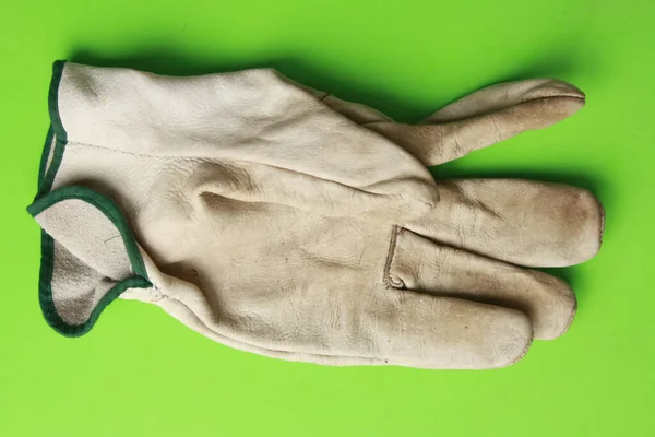 绿色背景的脏工作手套的顶部视图 — 图库照片