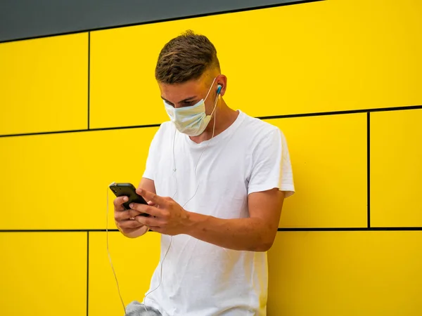 Een Blanke Man Met Behulp Van Zijn Telefoon Gele Muur — Stockfoto