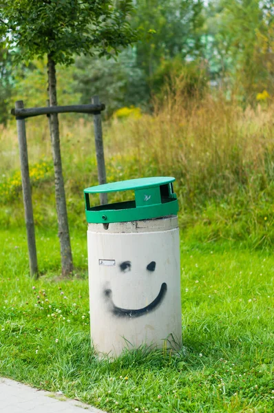 Una Cara Sonriente Dibujada Cubo Basura Sobre Hierba Verde Parque — Foto de Stock