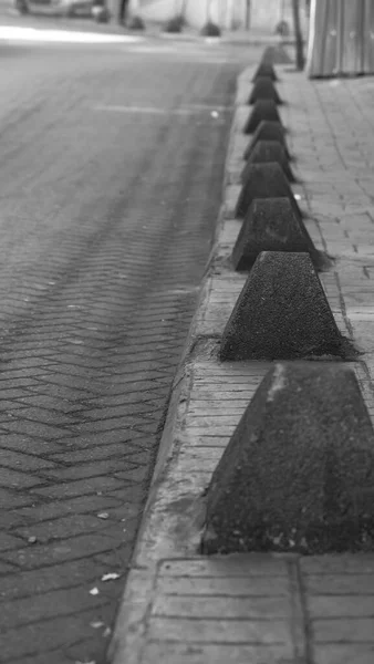 Een Grijswaarden Shot Van Scherpe Stenen Tussen Lege Straat Weg — Stockfoto