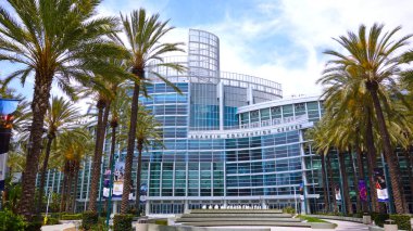 ANAHEIM, CA, UNITED STATES - Jul 22, 2019: The beautiful building of the Anaheim Convention Center with palm trees on a sunny day. clipart