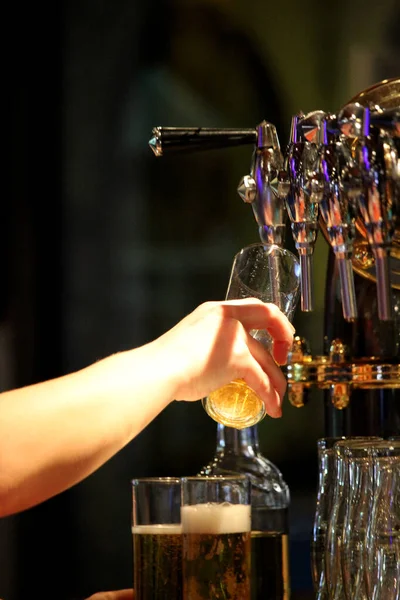 タップからグラスにビールを注ぐ手のクローズアップショット — ストック写真