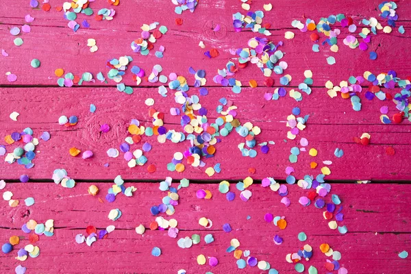 Tiro Alto Ângulo Confete Colorido Uma Superfície Madeira Rosa — Fotografia de Stock