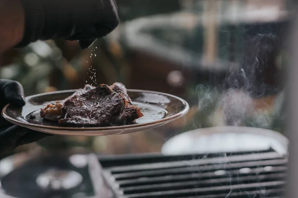 A closeup shot of a chef salting meat steak in a restaurant — Stock Image Closeup Shot Chef Salting Meat Steak Restaurant Royalty Free Stock Photos